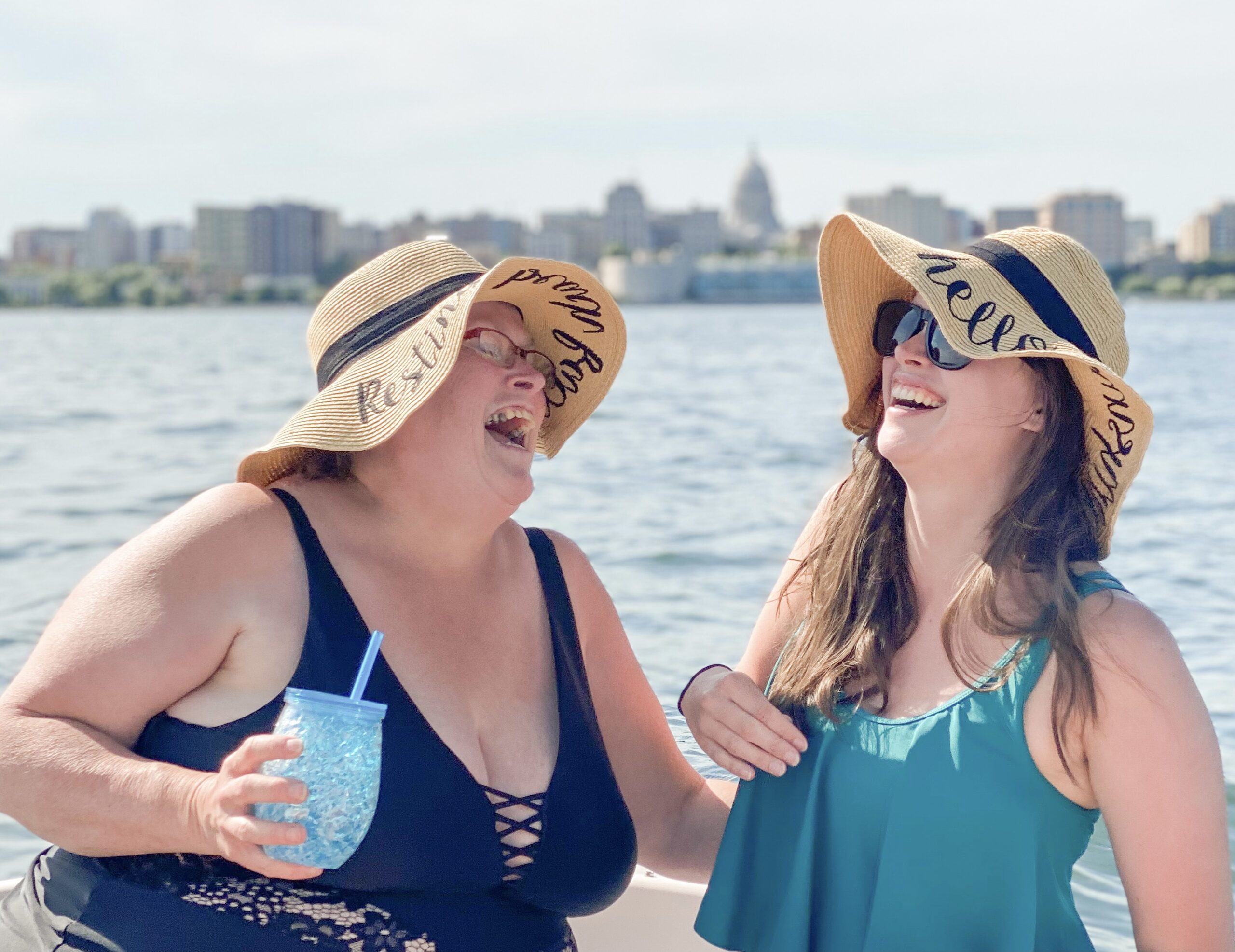 Mom and daughter laughing on a boat together.